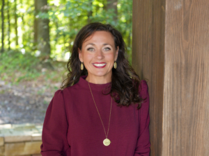 Heather Crozier standing leaned against a wood post outside