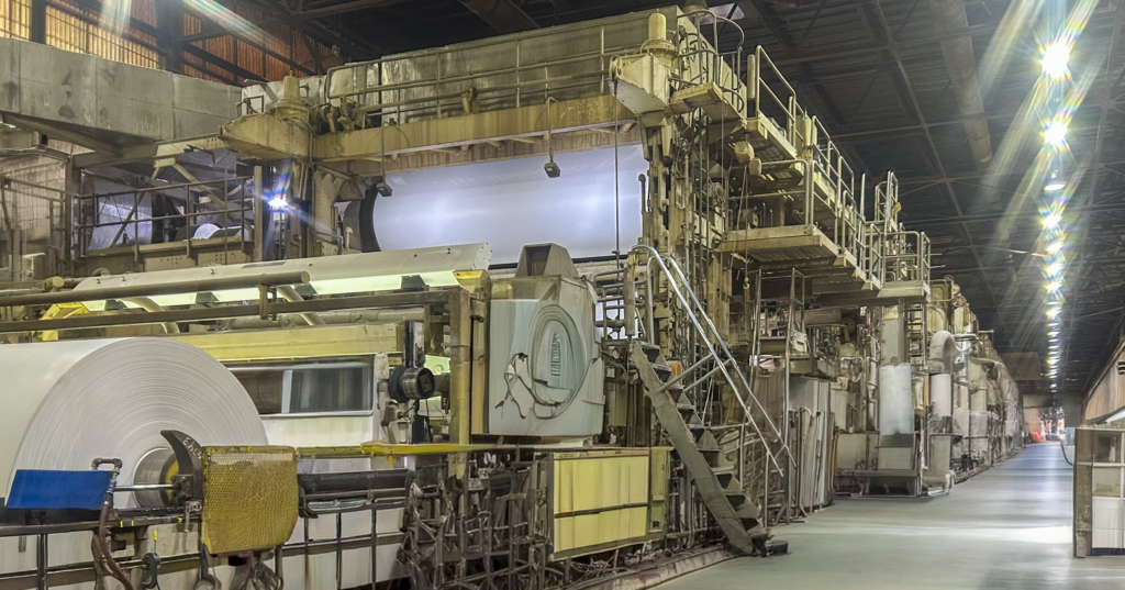 A large roll of containerboard moves through the production line at a South Alabama mill