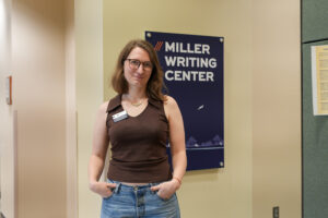 Katie Temple poses in front of the Miller Writing Center sign of the Forestry, Wildlife and Environment Building.